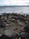 The section of the shore with boulders running into the water. The water is low.